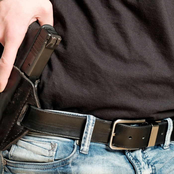 Gun Belt with Person Pulling Handgun Out of OWB Holster