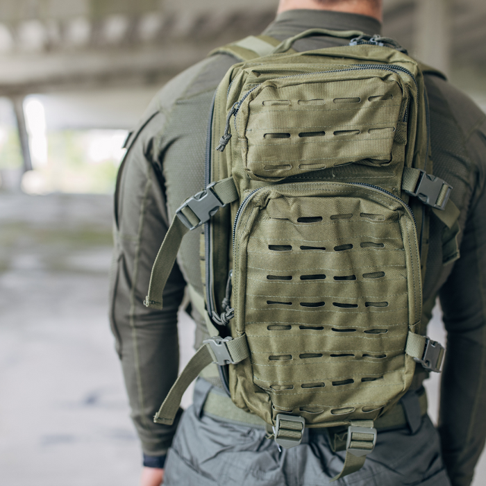 A man wearing a best tactical backpack walking in an abandoned warehouse in the background